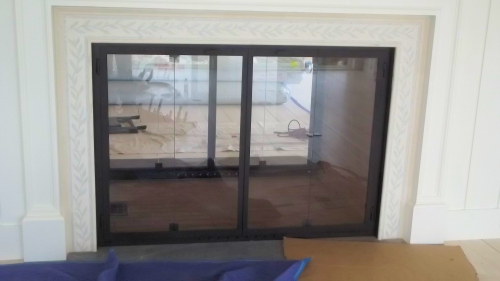 Photo of a see through with a New Seabury bi fold door,black finish  on see though fireplace side two